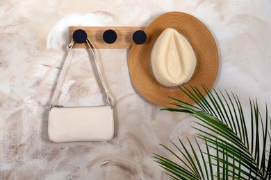 Stylish bag and hat on rack indoors