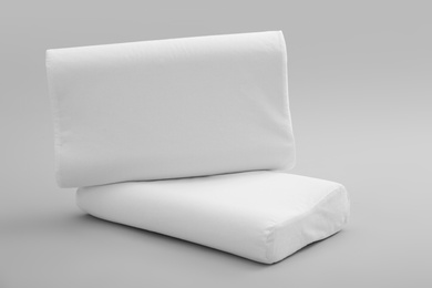 Photo of Clean soft orthopedic pillows on grey background