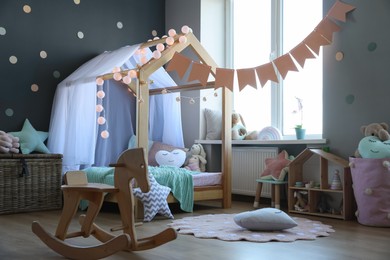 Stylish child room interior with house bed and different toys