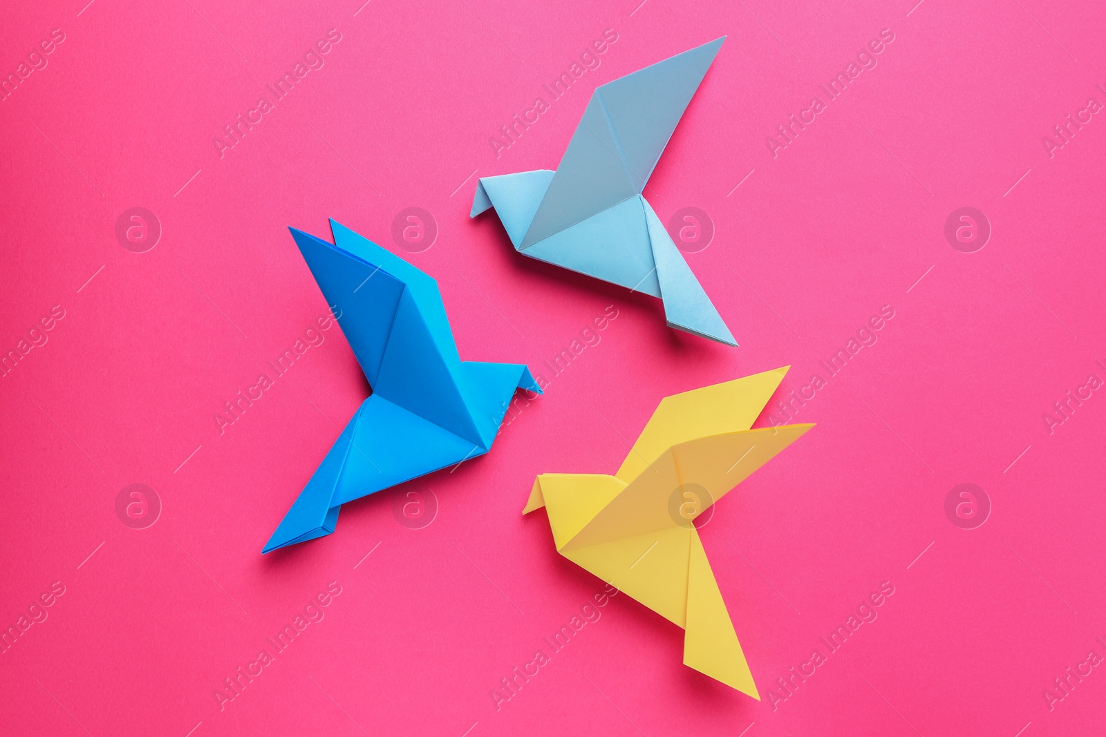 Photo of Beautiful colorful origami birds on pink background, flat lay