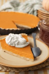 Photo of Piece of fresh homemade pumpkin pie served with whipped cream and tea on table