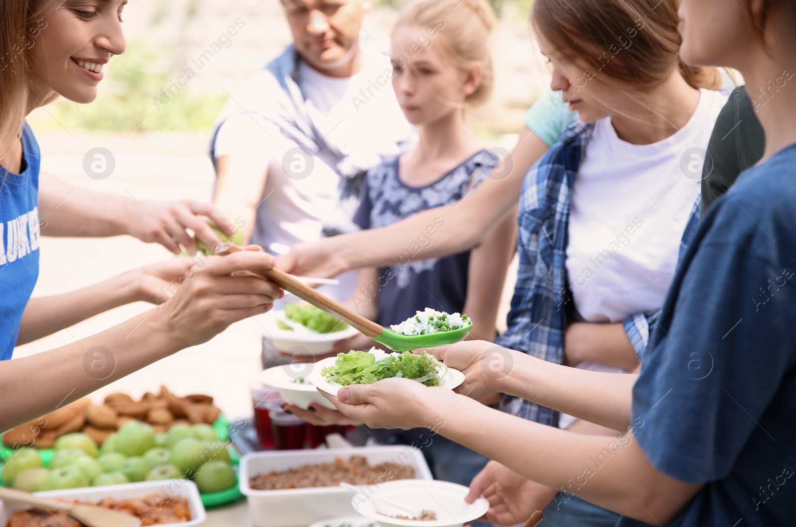 Photo of Volunteers serving food for poor people outdoors