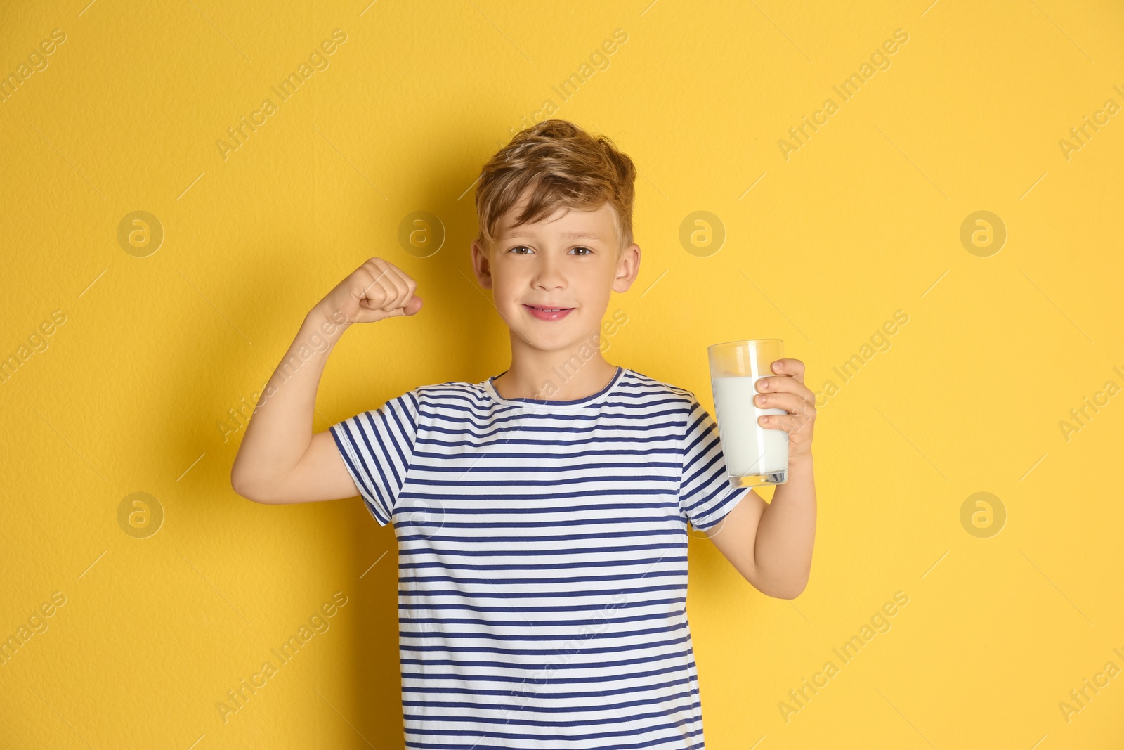 Photo of Adorable little boy with glass of milk on color background