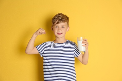 Photo of Adorable little boy with glass of milk on color background