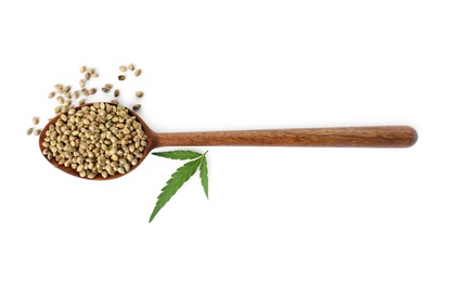 Photo of Spoon with hemp seeds and green leaf on white background, top view