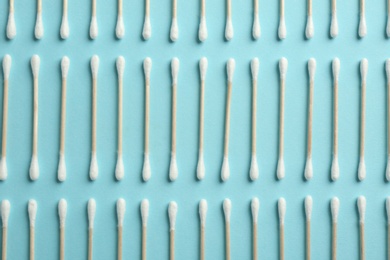 Photo of Flat lay composition with cotton swabs on color background