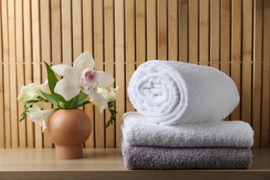 Terry towels and beautiful flowers on wooden table