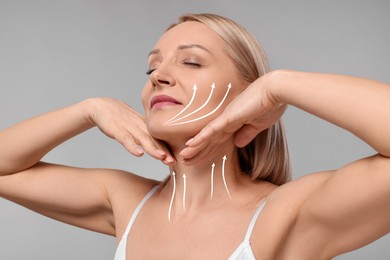 Woman with perfect skin after cosmetic treatment on grey background. Lifting arrows on her neck and face