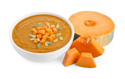 Delicious pumpkin cream soup with seeds in bowl and ingredients isolated on white