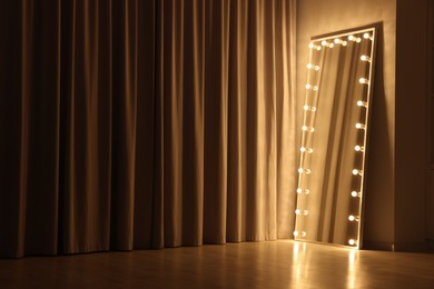 Photo of Modern mirror with light bulbs in makeup room