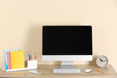 Computer with blank monitor at table indoors. Mock up for design