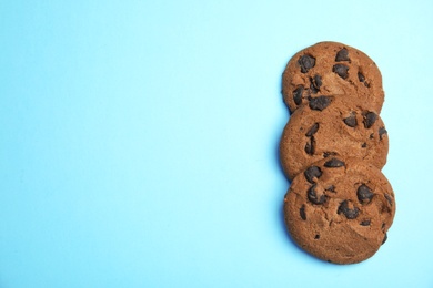 Delicious chocolate chip cookies on color background, flat lay. Space for text