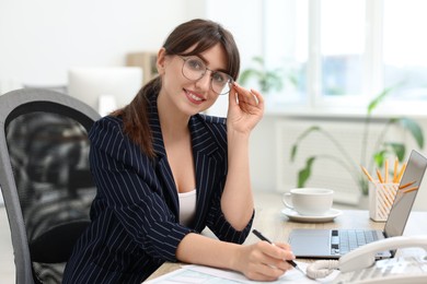 Photo of Portrait of smiling secretary at table in office