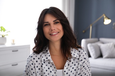 Young woman talking to her coworkers through video conference indoors, view from webcam