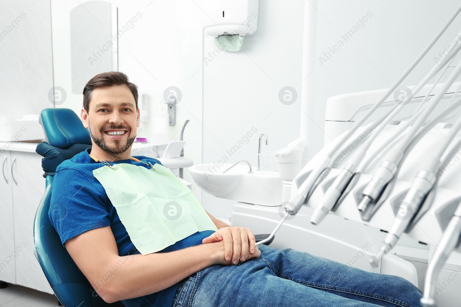 Photo of Happy man having dentist's appointment in modern office