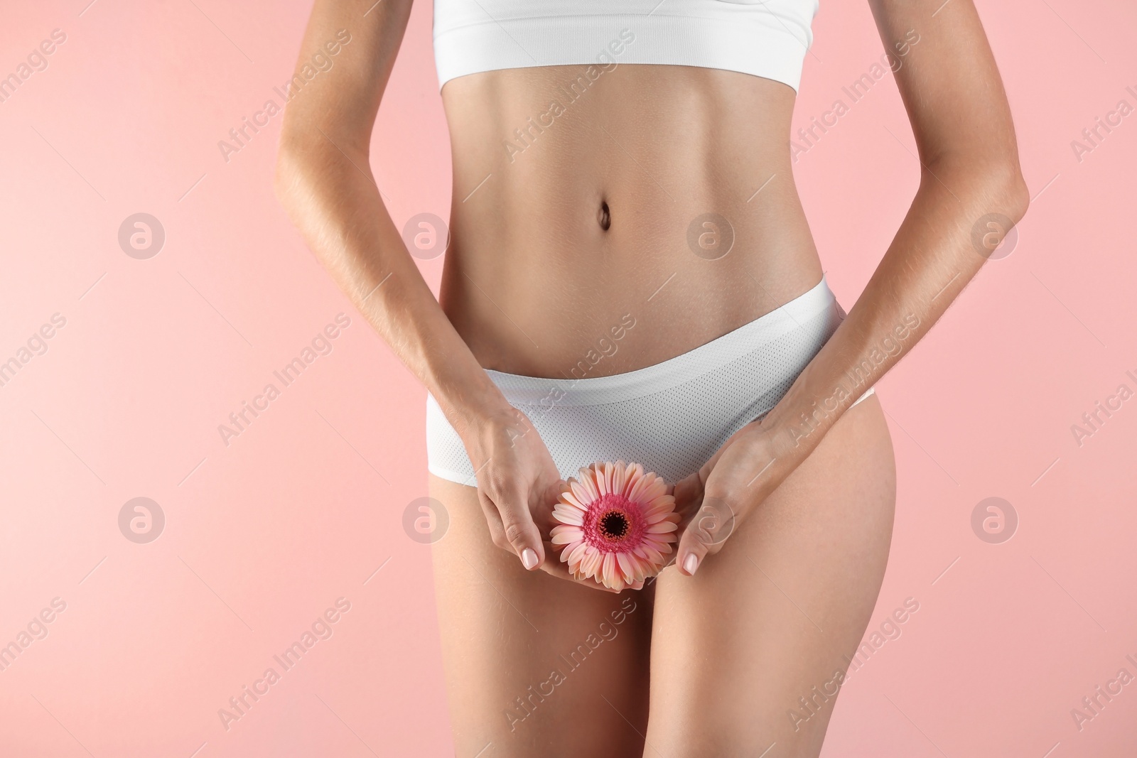 Photo of Young woman with gerbera flower on color background. Gynecology concept