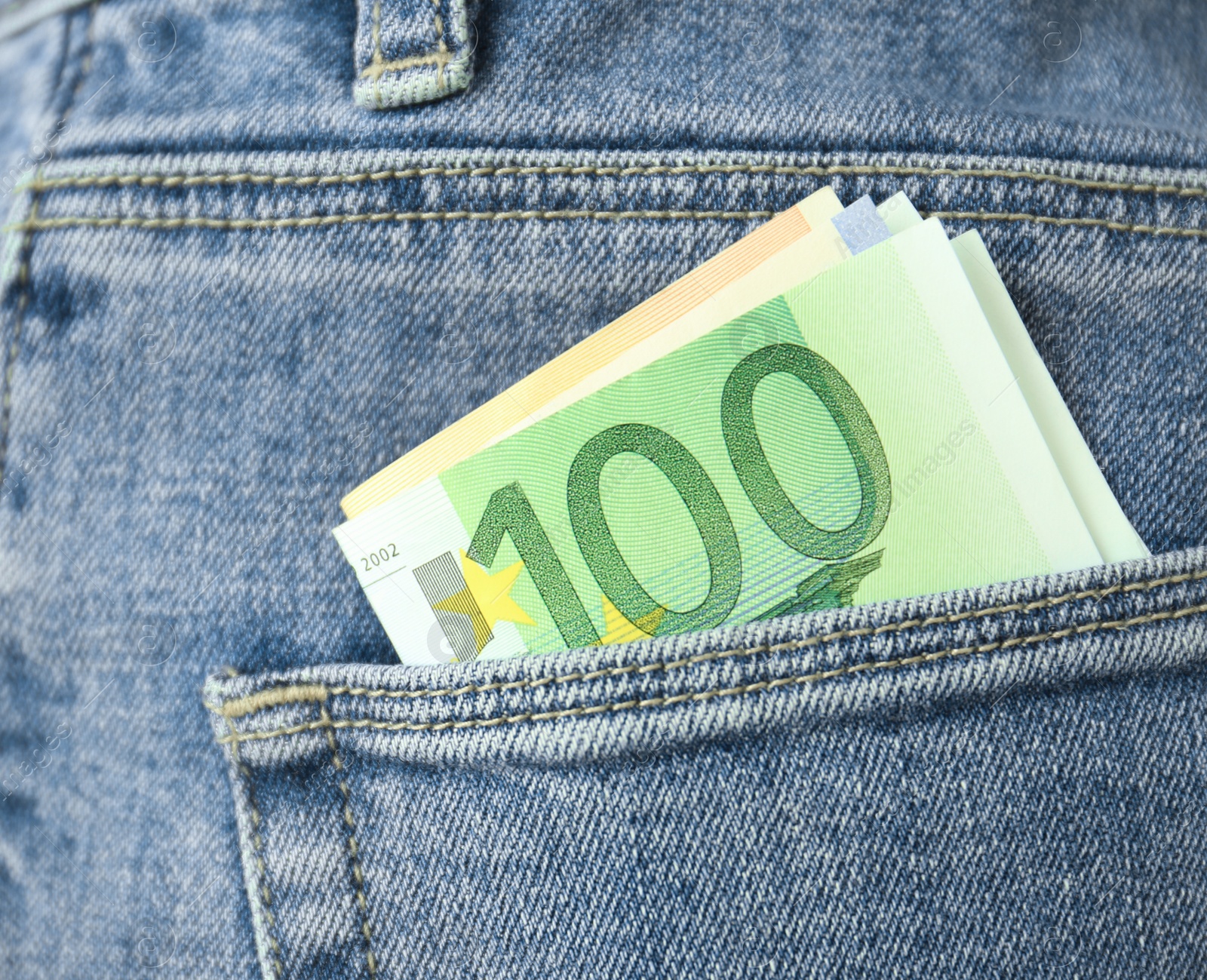 Photo of Person with Euro banknotes in pocket of jeans, closeup