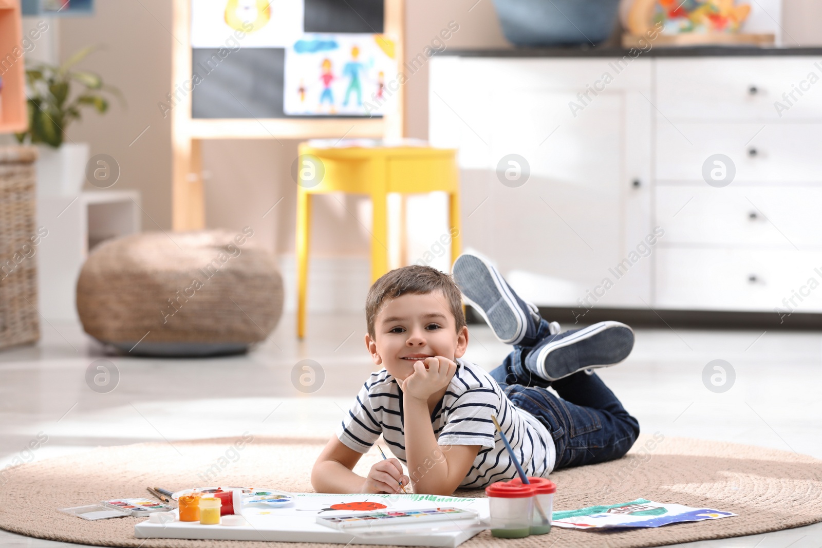 Photo of Little child painting on floor at home