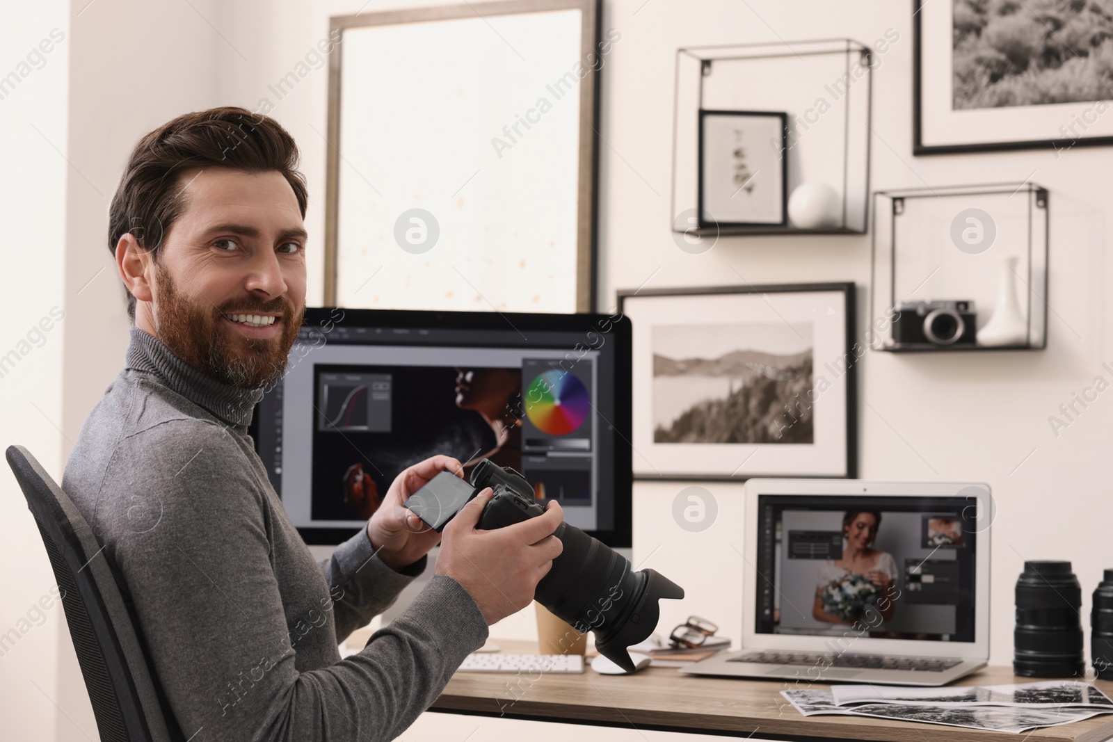 Photo of Professional photographer with digital camera at table in office