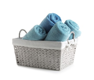 Photo of Rolled soft towels in basket on white background