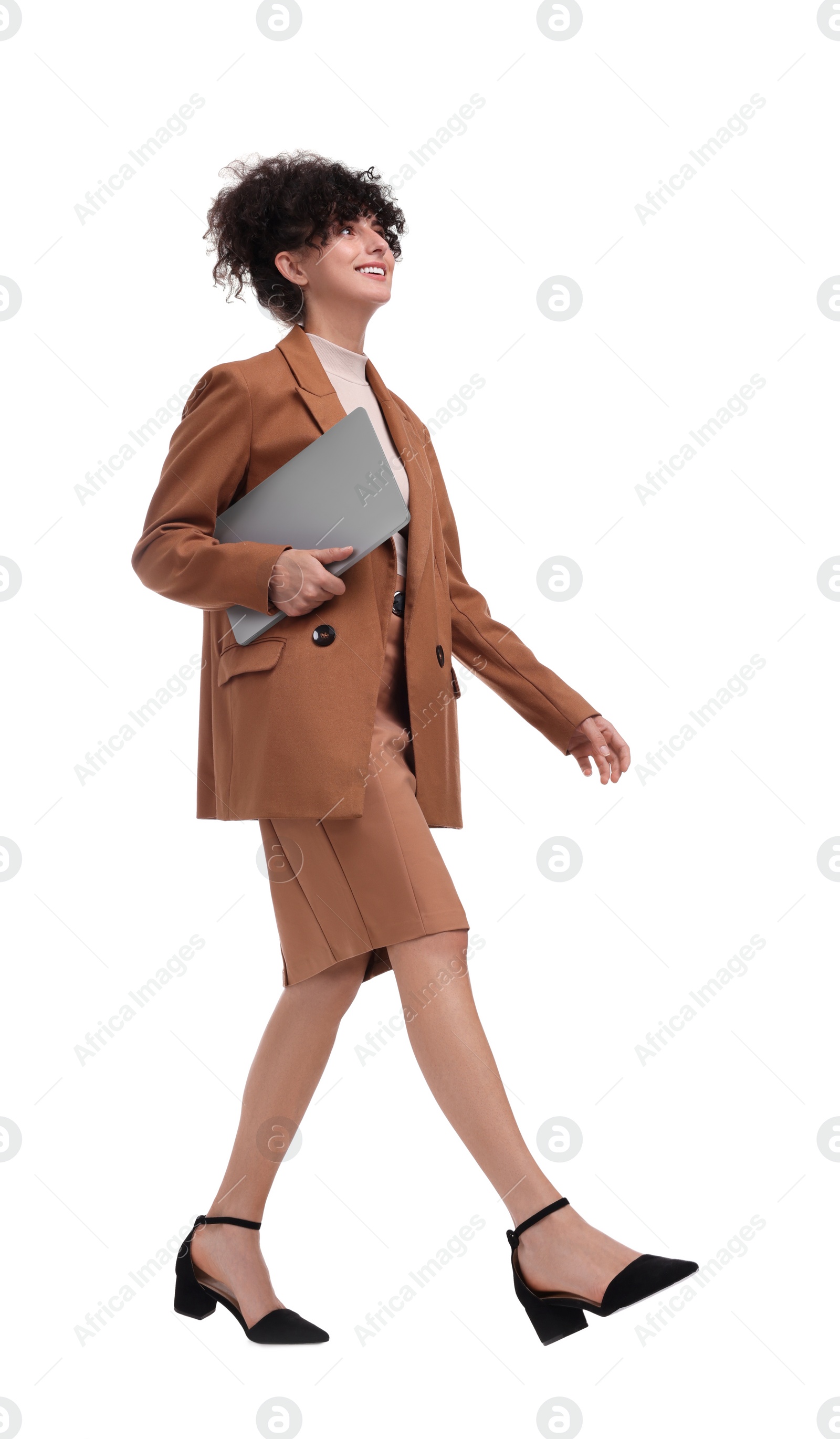 Photo of Beautiful happy businesswoman with laptop walking on white background