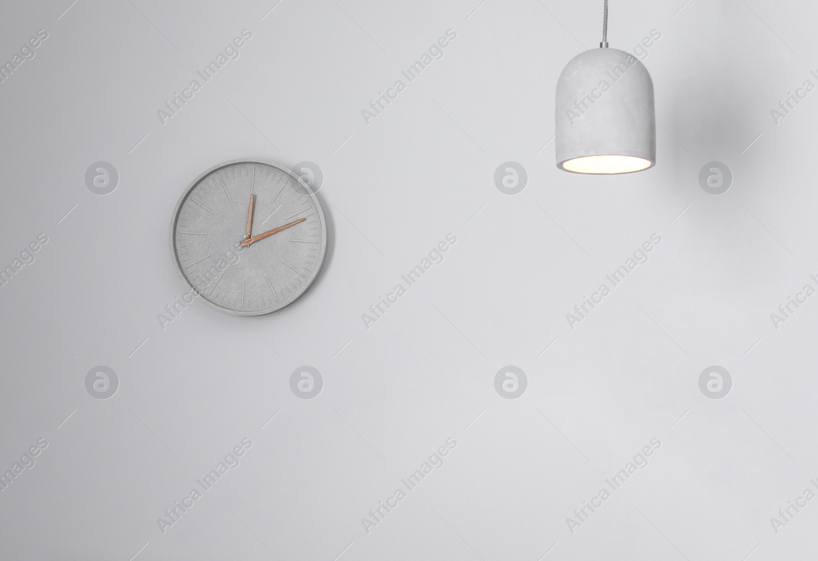 Photo of Analog clock hanging on white wall. Time of day