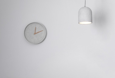 Analog clock hanging on white wall. Time of day