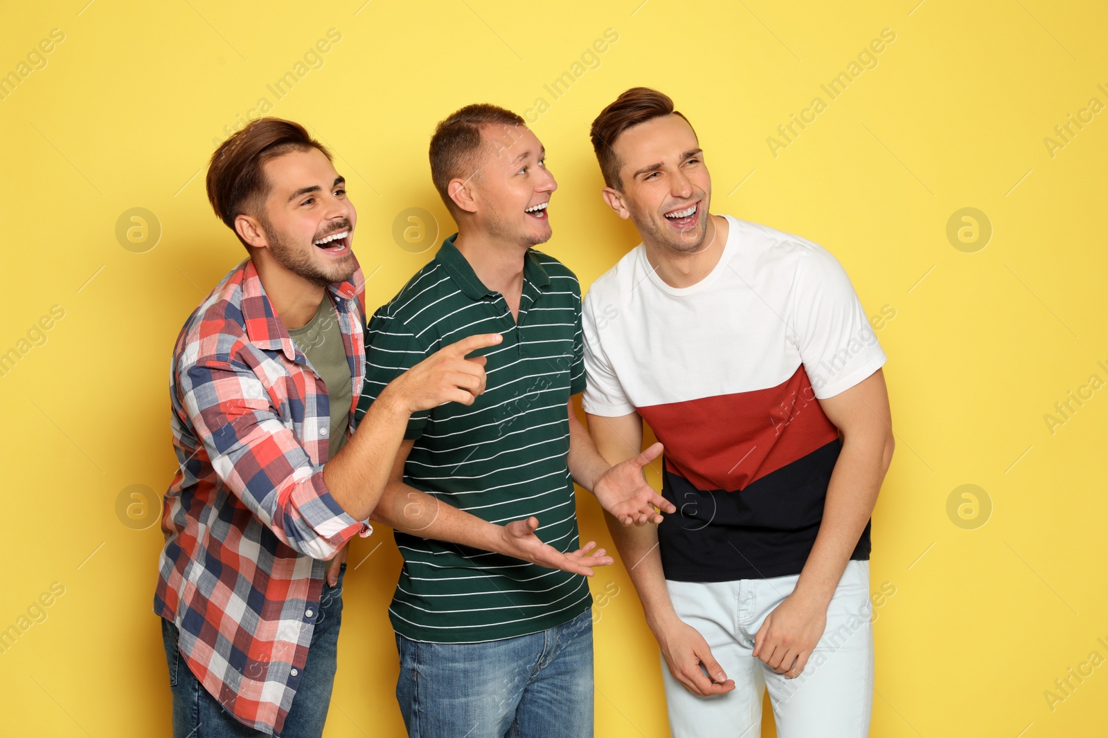 Photo of Group of friends laughing together against color background