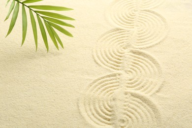 Photo of Zen rock garden. Wave pattern and green leaf on beige sand