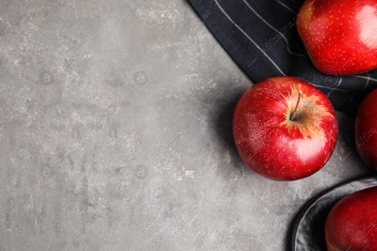 Photo of Ripe juicy red apples on grey background, flat lay. Space for text