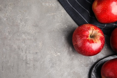 Ripe juicy red apples on grey background, flat lay. Space for text