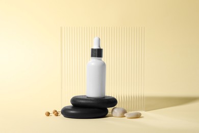 Composition with bottle of cosmetic serum on beige background