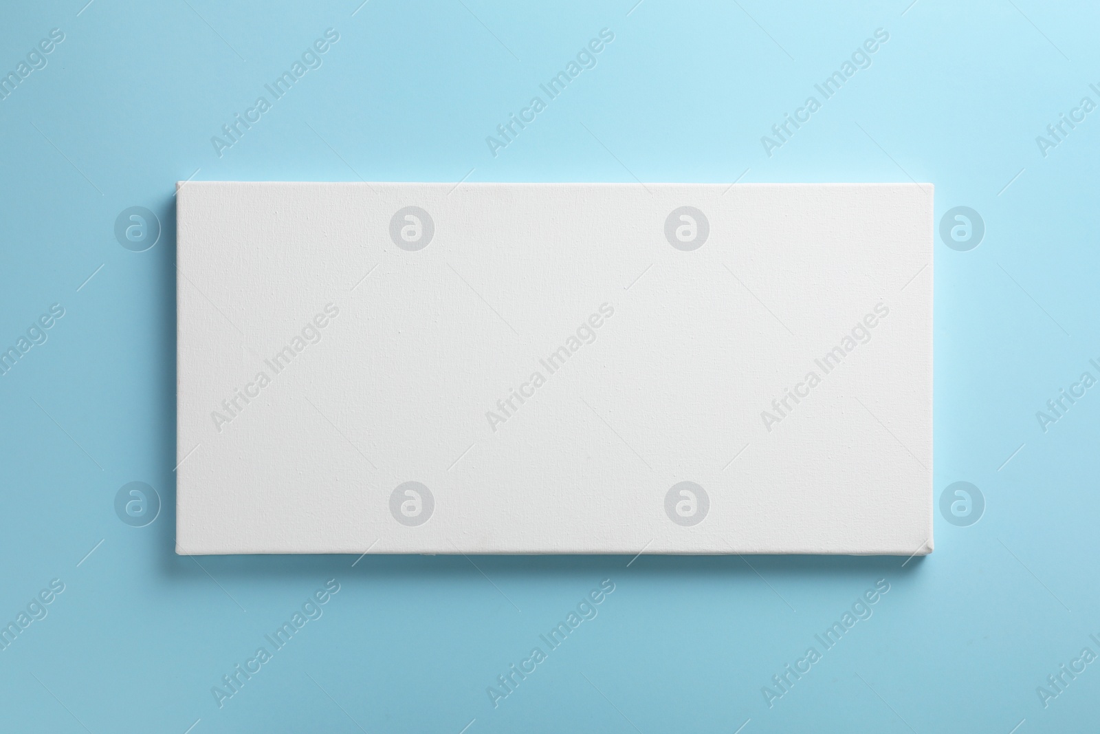 Photo of Blank canvas on light blue background, space for text