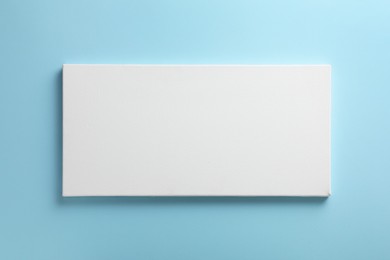 Photo of Blank canvas on light blue background, space for text