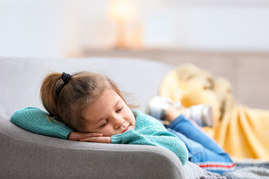 Photo of Cute little girl sleeping on sofa at home