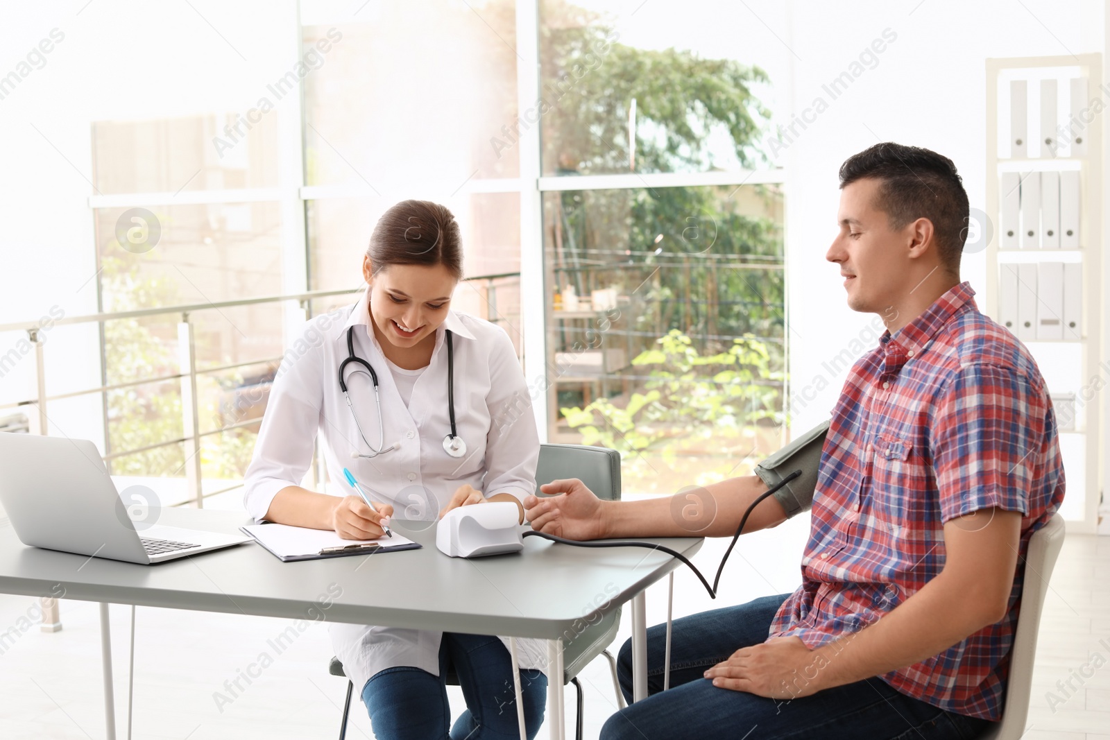 Photo of Doctor checking patient's blood pressure in hospital