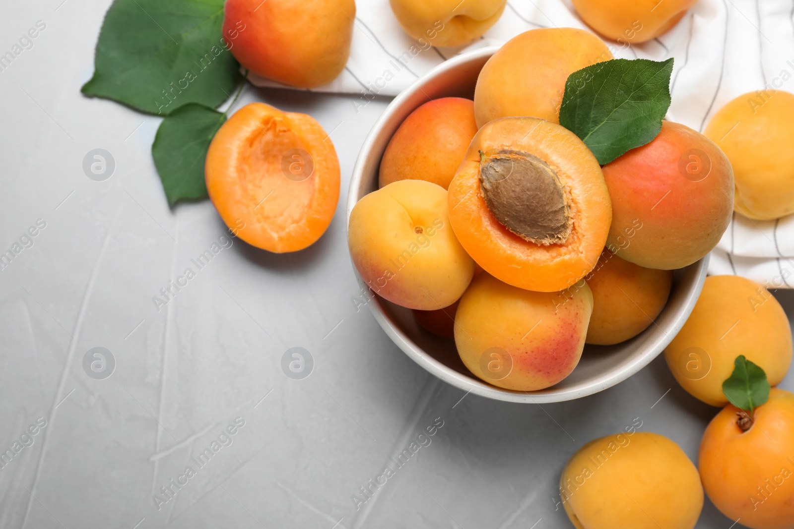 Photo of Many fresh ripe apricots on light grey table, flat lay