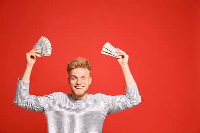 Photo of Portrait of happy lottery winner with money on red background