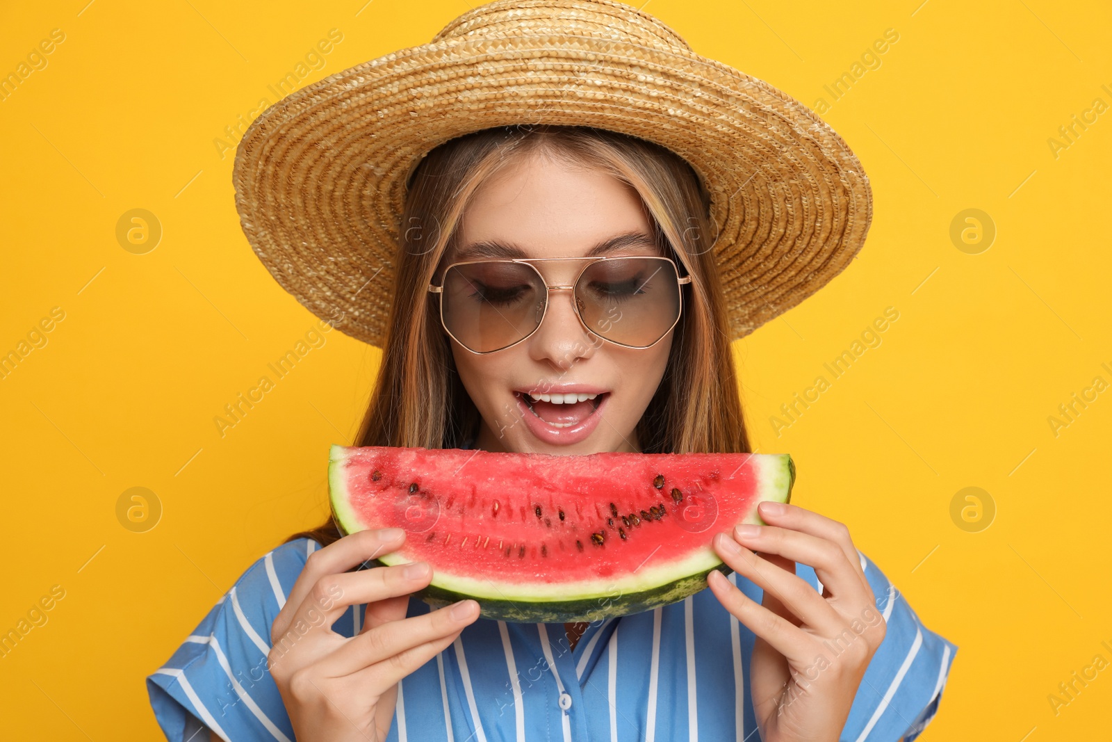 Photo of Beautiful girl with slice of watermelon on yellow background