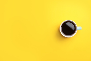 Photo of Ceramic cup with hot aromatic coffee on color background, top view