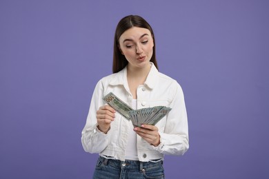 Woman with dollar banknotes on purple background