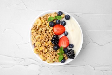 Photo of Tasty oatmeal, yogurt and fresh berries in bowl on white textured table, top view. Healthy breakfast