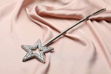 Photo of Beautiful silver magic wand on pink fabric