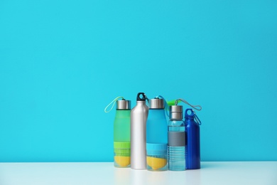 Different water bottles for sports on color background. Space for text