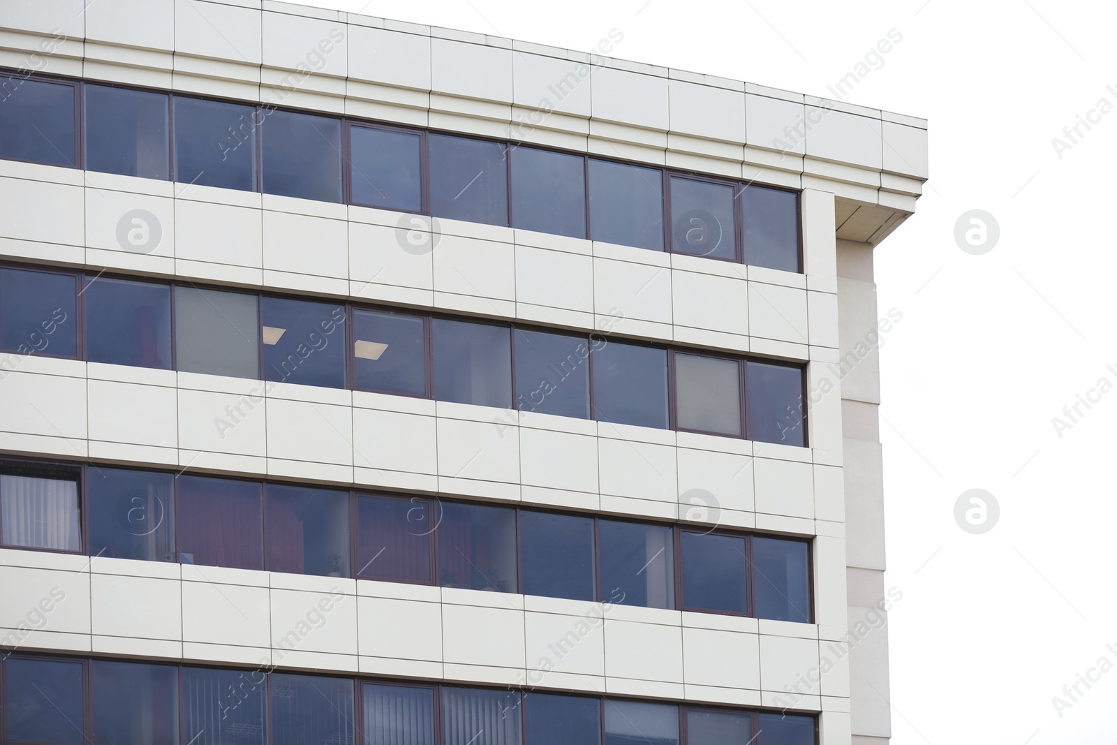 Photo of Modern building with tinted windows against sky. Urban architecture