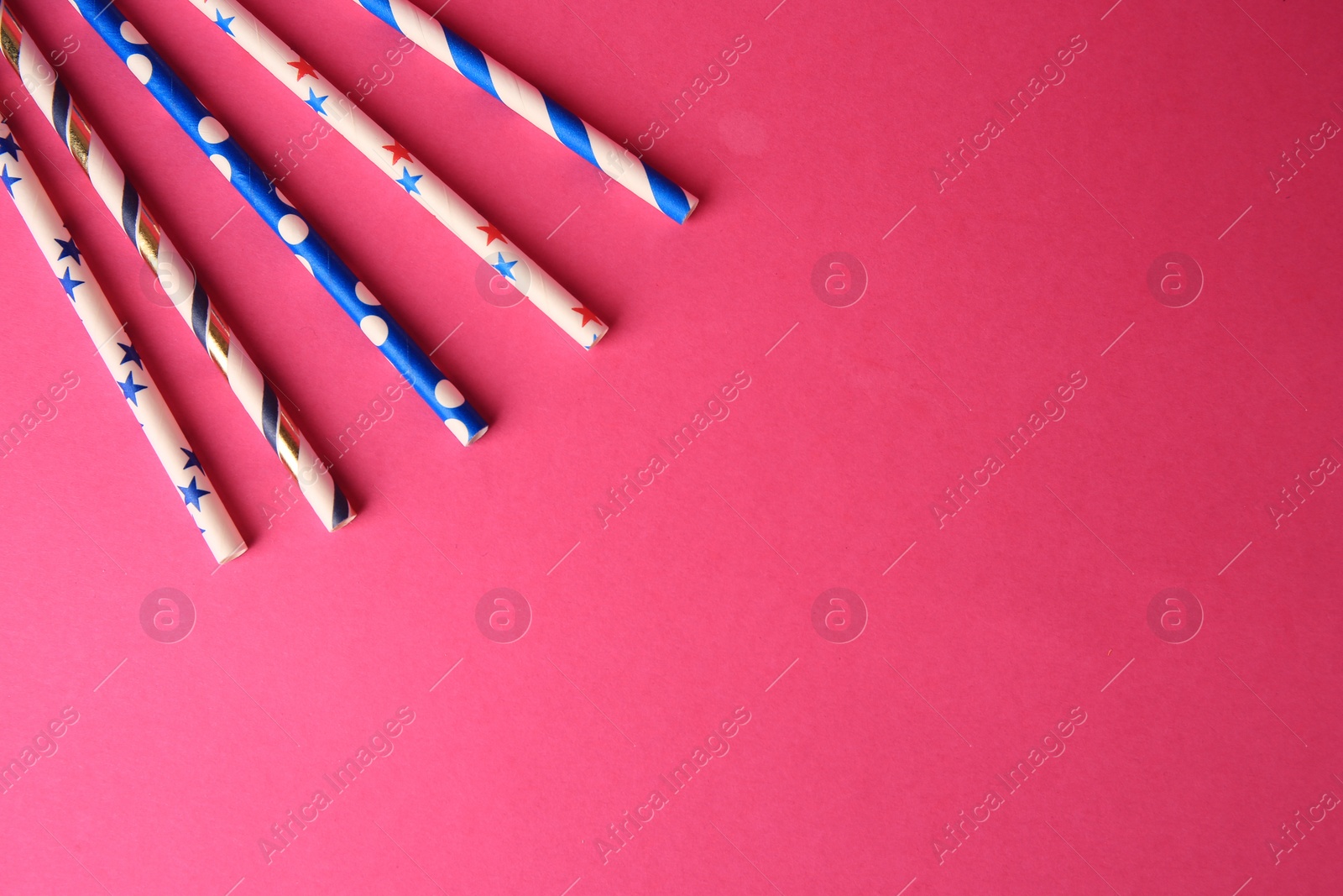 Photo of Paper drinking straws on pink background, flat lay Space for text