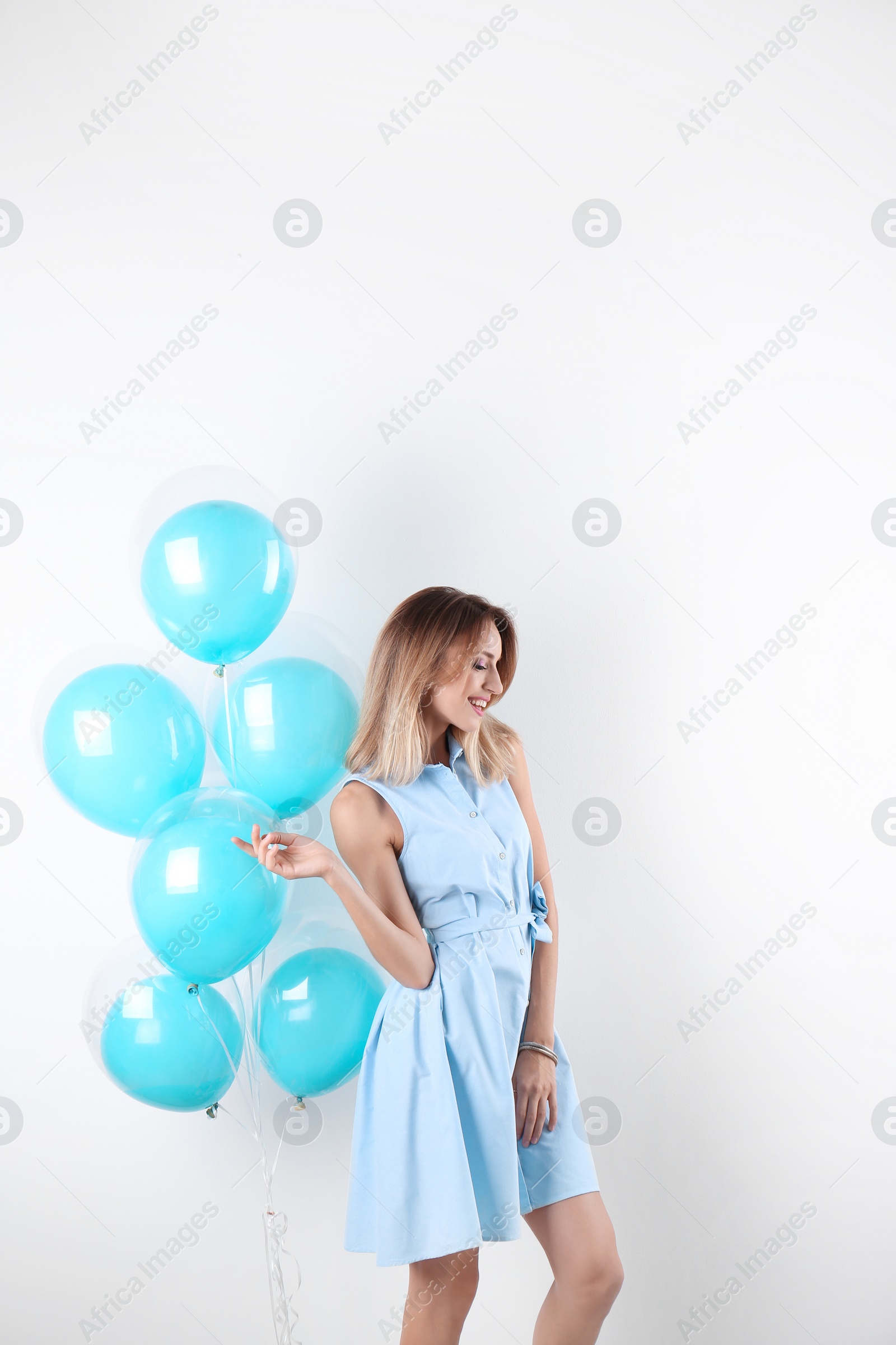 Photo of Young woman with air balloons on white background