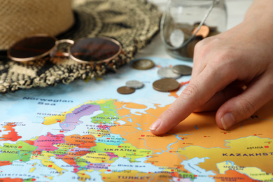 Woman with world map at table, closeup. Travel during summer vacation