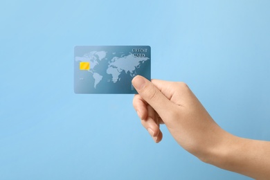 Photo of Woman holding credit card on color background