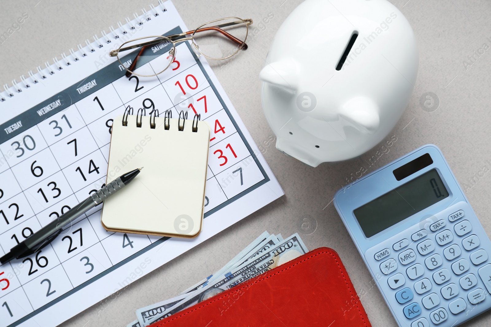 Photo of Flat lay composition with piggy bank and calculator on light grey background
